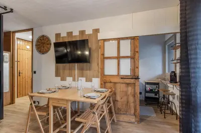 a dining room with a wooden table and chairs at La vue du Rosay - Balcon - Vues in Saint-Gervais-les-Bains