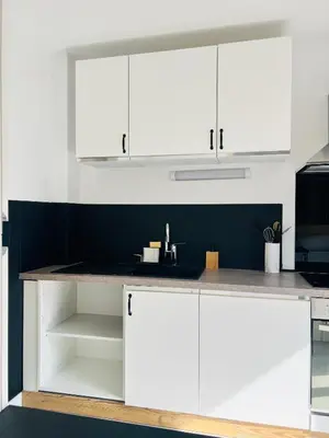 a kitchen with white cabinets and a counter top at Balcons Alpins - Appartement rénové à St-Gervais in Saint-Gervais-les-Bains