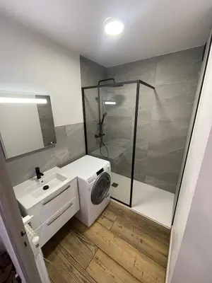 a bathroom with a washing machine and a shower at Balcons Alpins - Appartement rénové à St-Gervais in Saint-Gervais-les-Bains