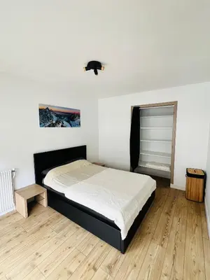 a bedroom with a bed and a mirror at Balcons Alpins - Appartement rénové à St-Gervais in Saint-Gervais-les-Bains