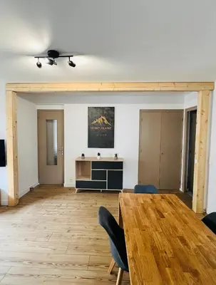 a living room with a wooden table and chairs at Balcons Alpins - Appartement rénové à St-Gervais in Saint-Gervais-les-Bains