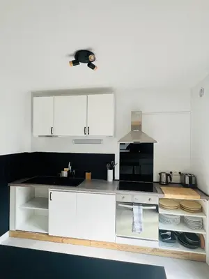 a kitchen with white cabinets and a counter top at Balcons Alpins - Appartement rénové à St-Gervais in Saint-Gervais-les-Bains