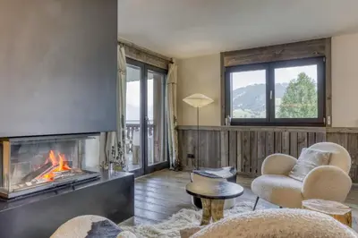 a living room with a fireplace and chairs at Paradiso in Megève