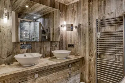 a bathroom with two sinks on a wooden wall at Paradiso in Megève