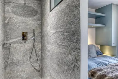 a bathroom with a shower and a bed at Paradiso in Megève
