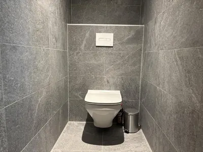 a bathroom with a toilet in a tiled wall at Le Yeti (4 Pers) in Chamonix-Mont-Blanc
