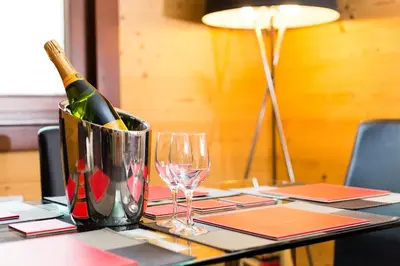 a table with a bottle of champagne and wine glasses at Le Paradis 24 apartment - Chamonix All Year in Chamonix-Mont-Blanc