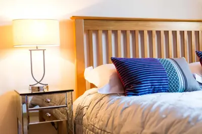 a bedroom with a bed with a lamp on a night stand at Le Paradis 24 apartment - Chamonix All Year in Chamonix-Mont-Blanc