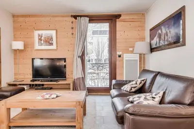 a living room with a couch and a tv at Le Paradis 27 apartment - Chamonix All Year in Chamonix-Mont-Blanc