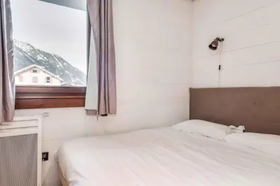 a small bedroom with a bed and a window at Le Paradis 27 apartment - Chamonix All Year in Chamonix-Mont-Blanc