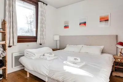 a bedroom with a white bed with two towels on it at Le Paradis 27 apartment - Chamonix All Year in Chamonix-Mont-Blanc