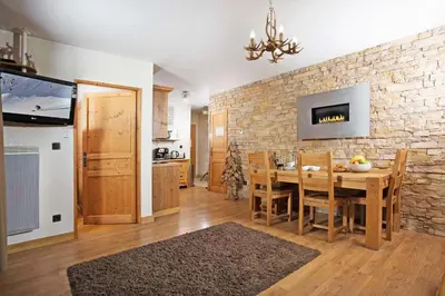 a kitchen and dining room with a table and a brick wall at Le Paradis 8 apartment - Chamonix All Year in Chamonix-Mont-Blanc