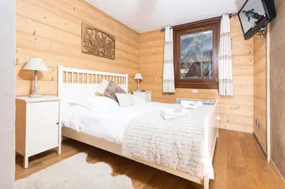 a bedroom with a white bed and a window at Le Paradis 8 apartment - Chamonix All Year in Chamonix-Mont-Blanc
