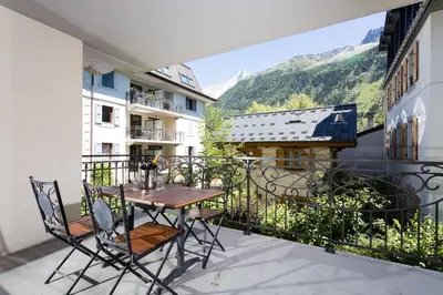 a table and chairs on a balcony with a view at Le Paradis 8 apartment - Chamonix All Year in Chamonix-Mont-Blanc