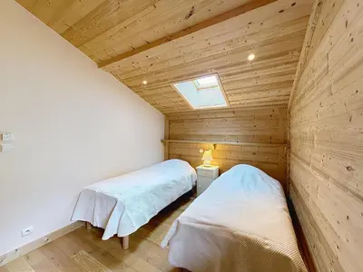 two beds in a room with wooden walls at Appartement 2 chambres, mezzanine, vue Mont Blanc, proche village, parking - FR-1-560-164 in Combloux
