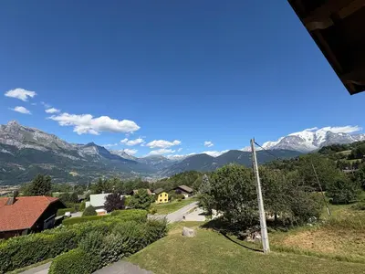 a view of a village with mountains in the background at Appartement 2 chambres, mezzanine, vue Mont Blanc, proche village, parking - FR-1-560-164 in Combloux