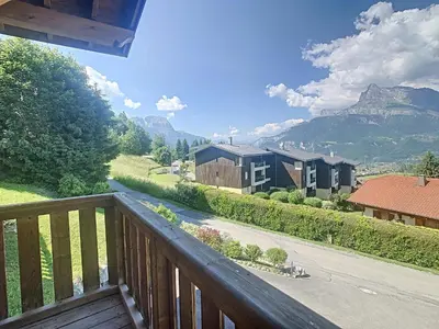 a balcony with a view of a house and mountains at Appartement 2 chambres, mezzanine, vue Mont Blanc, proche village, parking - FR-1-560-164 in Combloux