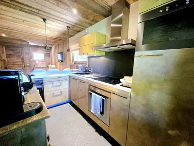 a large kitchen with a stove and a refrigerator at Cozy apartment in Mègeve center in Megève