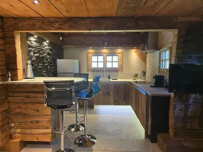 a kitchen with a counter and a blue bar stool at Le Mazot in Megève