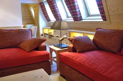 a living room with two red chairs and a lamp at Le Paradis 18 - Chamonix All Year in Chamonix-Mont-Blanc