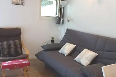 a living room with a blue couch and a chair at Studio avec vue sur les montagnes in Les Contamines-Montjoie