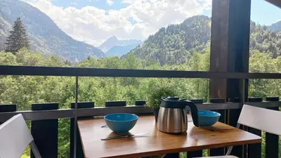 a table with two bowls and a tea kettle on a balcony at Studio avec vue sur les montagnes in Les Contamines-Montjoie