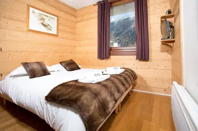 a bedroom with a large bed with a blanket on it at Le Paradis ski apartment - Chamonix All Year in Chamonix-Mont-Blanc
