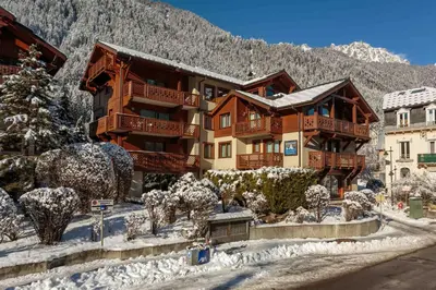 a large building in the snow in front of a mountain at Chamois Apartment- Chamonix All Year in Chamonix-Mont-Blanc