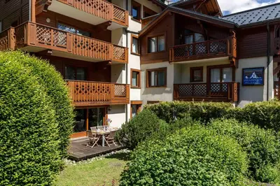 an apartment building with a balcony and a table at Chamois Apartment- Chamonix All Year in Chamonix-Mont-Blanc