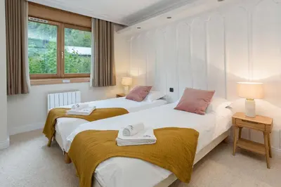 a bedroom with two beds and a window at Chamois Apartment- Chamonix All Year in Chamonix-Mont-Blanc