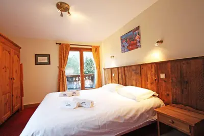 a bedroom with a large bed with two towels on it at La Ferme des Praz apartment - Chamonix All Year in Chamonix-Mont-Blanc