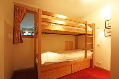a bedroom with two bunk beds and a window at La Ferme des Praz apartment - Chamonix All Year in Chamonix-Mont-Blanc