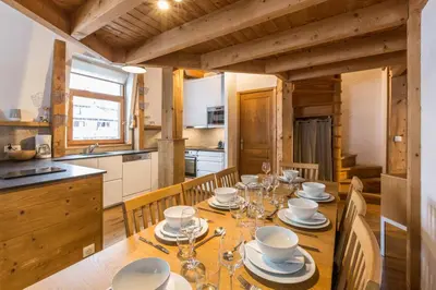 a dining room with a table and a kitchen at Apartment Vila 2 - Charming 2 Bedroom Haven in Chamonix in Chamonix-Mont-Blanc