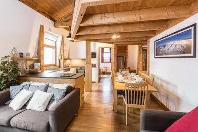 a living room and kitchen with a couch and a table at Apartment Vila 2 - Charming 2 Bedroom Haven in Chamonix in Chamonix-Mont-Blanc