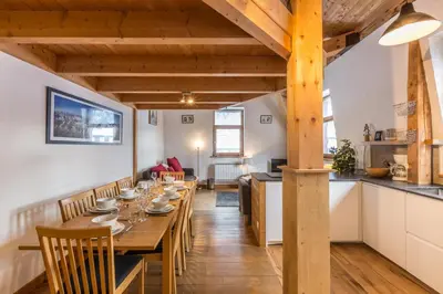 a dining room with a long table and a kitchen at Apartment Vila 2 - Charming 2 Bedroom Haven in Chamonix in Chamonix-Mont-Blanc