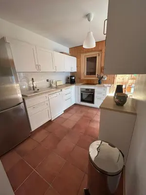 a kitchen with white cabinets and a tile floor at Carpe Diem in Sixt