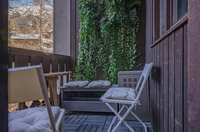 a porch with a chair and a bench with pillows at Apartment Jonquille 2C - Chamonix Peaks Getaway in Chamonix-Mont-Blanc