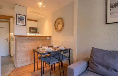 a dining room with a table and a couch at Apartment Jonquille 2C - Chamonix Peaks Getaway in Chamonix-Mont-Blanc