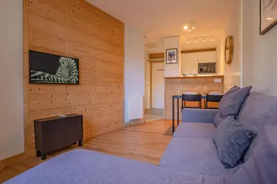 a living room with a couch and a kitchen at Apartment Jonquille 2C - Chamonix Peaks Getaway in Chamonix-Mont-Blanc