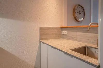 a kitchen with a sink and a clock on the wall at Apartment Jonquille 2C - Chamonix Peaks Getaway in Chamonix-Mont-Blanc