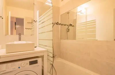 a bathroom with a shower and a sink and a washing machine at Apartment Jonquille 2C - Chamonix Peaks Getaway in Chamonix-Mont-Blanc