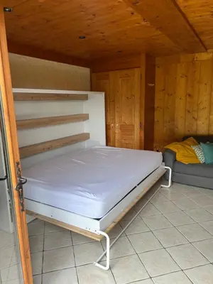 a bedroom with a bed in a wooden room at Studio vallée de Chamonix in Les Houches