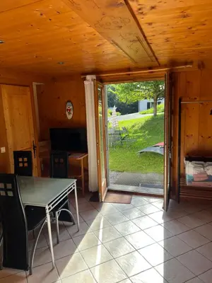 a dining room with a table and a sliding glass door at Studio vallée de Chamonix in Les Houches