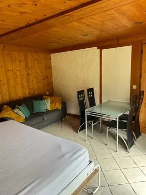 a room with a bed and a table and chairs at Studio vallée de Chamonix in Les Houches