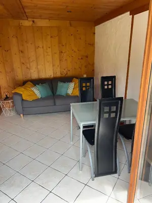 a living room with a couch and a table and chairs at Studio vallée de Chamonix in Les Houches
