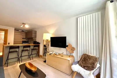 a living room with a couch and a chair and a table at Parenthèse Rochebrune in Megève