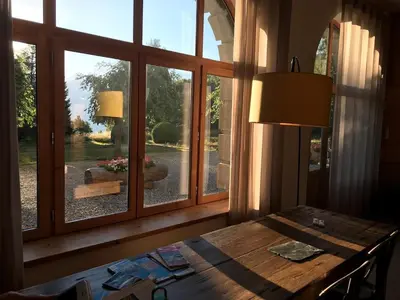 a wooden table in a room with a window at Grand appartement familial in Combloux