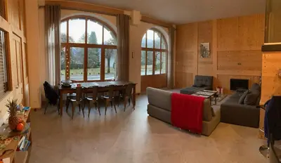 a living room with a couch and a table and chairs at Grand appartement familial in Combloux