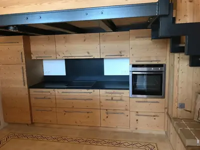 a kitchen with wooden cabinets and a stove at Grand appartement familial in Combloux