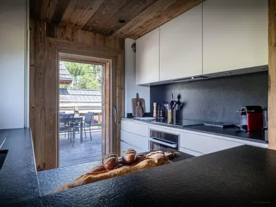 a kitchen with a counter with a table in it at Chalet Snow Love - OVO Network in Megève